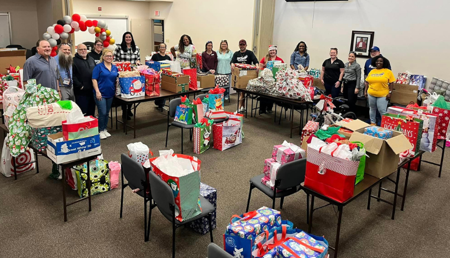 Tax Collector, Charles W. Thomas (far left), and members of his team with R’Club employees and holiday gift donations.